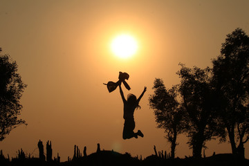 silhouette of a woman jumping in sunset