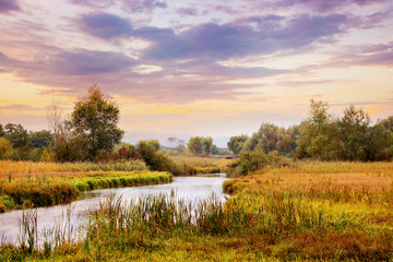 Fototapeta na wymiar Picturesque autumn landscape with river and cloudy sky at sunset