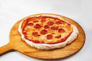 Wood-fired pizza served on wooden table on a white background