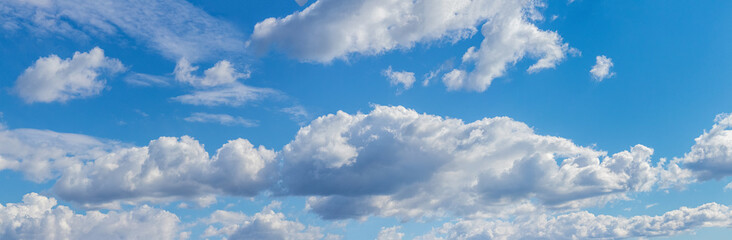White fluffy clouds on a blue sky, panorama