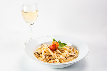Spaghetti dish served with sauce and accompanied by a glass of white wine