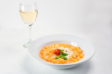Gnocchi dish served with sauce and accompanied by a glass of white wine
