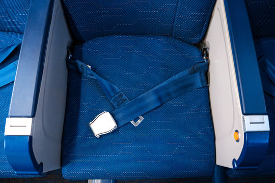An unfastened seat belt on an empty seat in an airplane. Safety in flight