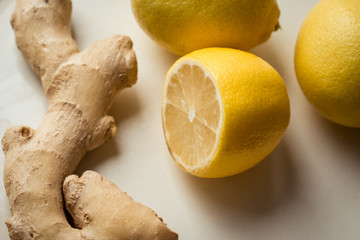 three lemons and ginger lie on a white background. anti-cold tea recipe. protection from disease