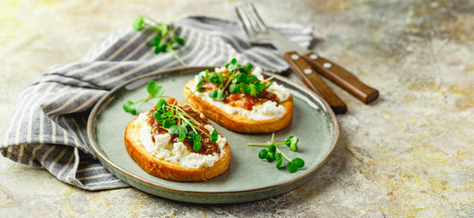 Canape or crostini with toasted baguette, cottage cheese, fig jam