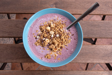 Healthy breakfast, home made strawberry, blueberry, banana and yoghurt smoothie with crunchy muesli and oat flakes