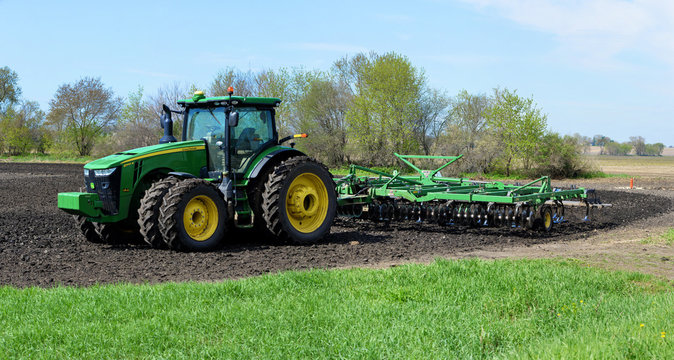 ROSCOE, ILLINOIS - May 2,2020: John Deere 8345R tractor pulling a 2310 mulch finisher