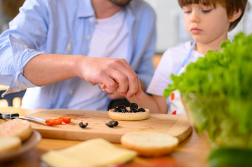 Mono-parental father and kid making sandwiches. Home cooking.
