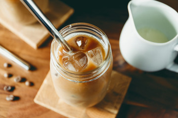 Top view of a glass jar with iced latte on a table