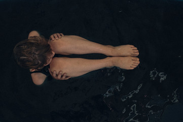 Obraz na płótnie Canvas black bath alone scared young girl