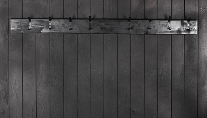 old black wooden hanger on a black wooden wall