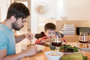 Young family with a little child sitting together for lunch