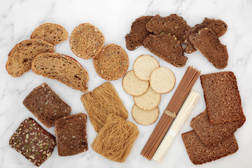 Low glycemic food for a diabetic diet with bread, pasta, oatmeal crackers & noodles, high in antioxidants & smart carbs. Below 55 on the GI index. Top view on marble.