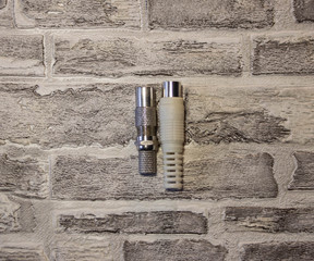 Metal and plastic plug for the antenna in the televisor on the background of a brick wall..