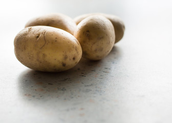 several potatoes on a light background closeup