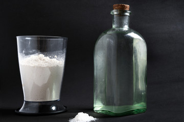 white wheat flour in a glass bowl and a cold water jug on a dark or black background