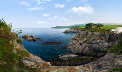 Fototapeta na wymiar High cliffs in the ocean. Rocky islands and rocks in Orlik Bay in the Sea of Japan. Far East.