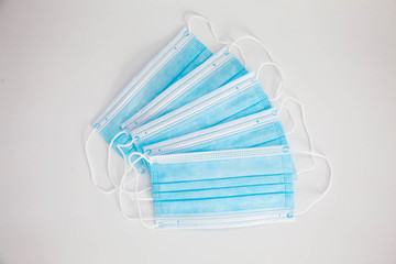 Blue protective medical masks lie on a white background