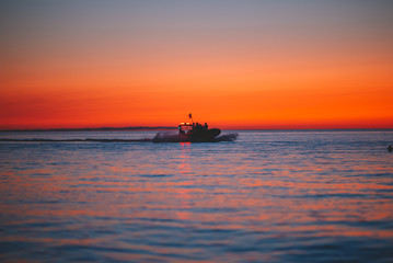 Fototapeta na wymiar Patrol ship silhouette at the sunset