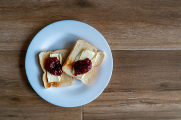 Two slices of toasted sandwich with Butter and Raspberry Jam. Breakfast. Top view. Free space for text.