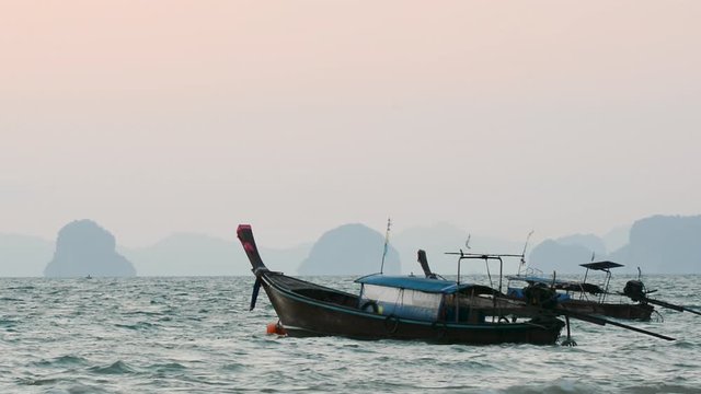 Traditional Thai long tail wooden boats rocking on the waves close to Railay beach in Krabi province, Thailand	