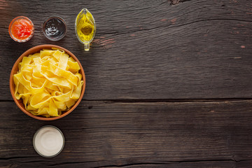 Pappardelle pasta with salmon. italian traditional cuisine. Finished ingredients on a wooden table with copy space.