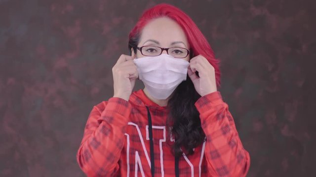 Mujer se quita el cubre bocas y respira profundamente, chica guapa mostrando c&oacute;mo poner un cubre bocas, mujer bonita de pelo rojo mostrando la aplicaci&oacute;n correcta de un cubre bocas