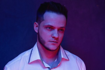 ortrait of handsome young man against studio background. Perfect hairstyle, modern stylish haircut. Attractive guy with fashion hairstyle. Confident man with short beard. Barbershop concept.