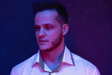 ortrait of handsome young man against studio background. Perfect hairstyle, modern stylish haircut. Attractive guy with fashion hairstyle. Confident man with short beard. Barbershop concept.