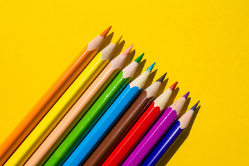 Color pencils isolated on yellow background close up