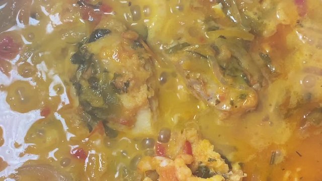Cooking a moqueca dish. Brazilian traditional food made with fish and shrimp, coconut milk and azeite de dende.