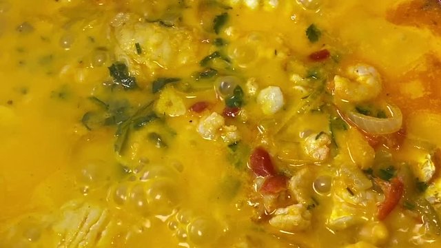 Cooking a moqueca dish. Brazilian traditional food made with fish and shrimp, coconut milk and azeite de dende.