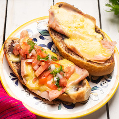 Mexican molletes with ham and cheese on white background