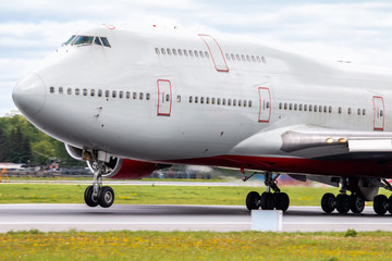 Obraz premium A large white wide-body passenger aircraft takes off from the airport runway