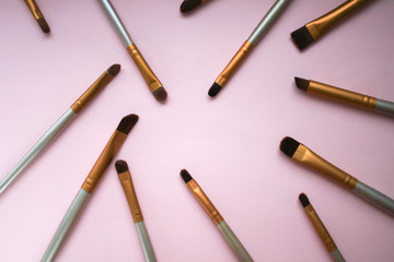 Makeup brushes on a pink background