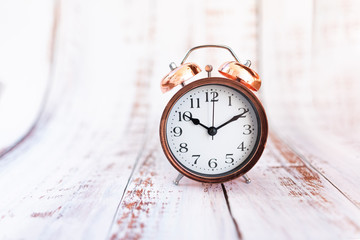 Retro vintage alarm clock on wooden background. Time concept. Isolated.