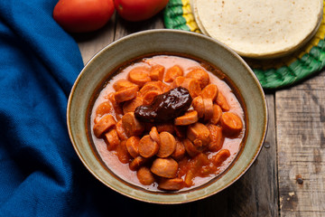 Mexican sausage with chipotle sauce on wooden background