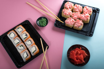Rolls with pink cream and Philadelphia roll in black plastic box