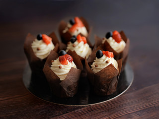 cupcakes sweet dessert a piece of cake in a beautiful paper package serving dessert individually Packed decorated with white cream and fresh berries