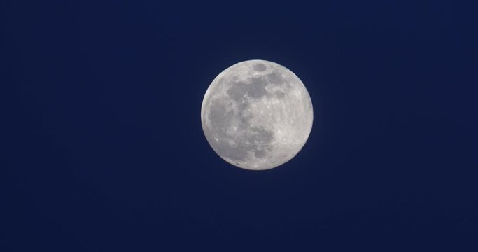full supermoon on deep blue sky at dusk