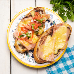 Mexican molletes with ham and cheese on white background