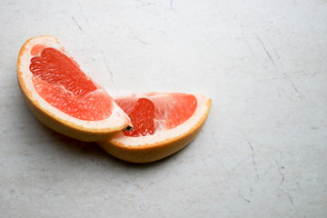 Pieces of grapefruit on a gray background