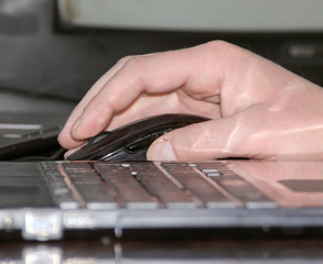 Man using a wireless mouse with a laptop, modern personal computer technology