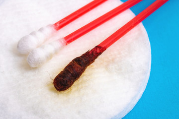 Cotton buds with medical iodine on blue background