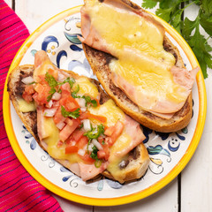 Mexican molletes with ham and cheese on white background