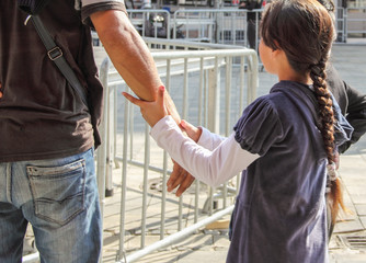 KOSOVO, NORTH KOSOVSKA MITROVICA September 09. 2018:A little girl with a braid holds her father's hand.