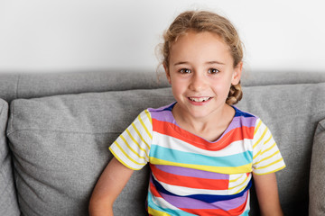 Smiling young girl sitting on couch