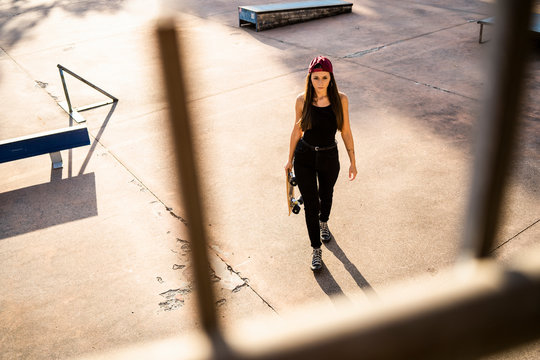 Young woman with skateboard at skatepark - Powered by Adobe