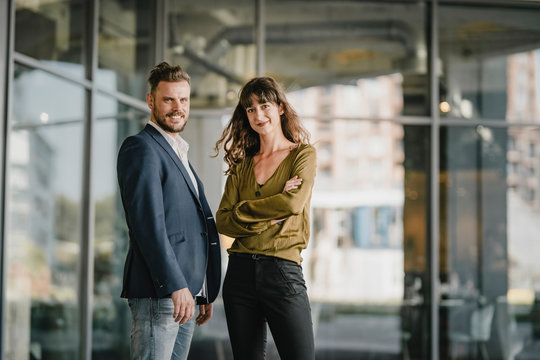 Portait Of Smiling Businessman And Casual Businesswoman Outdoors