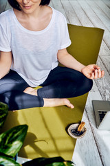 Female practicing yoga in quarantine at home. National yoga day. Healthy living in lockdown. Using...